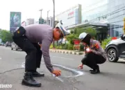 Hati-Hati, Polresta Bandar Lampung Tandai Jalan Rusak dan Berlubang Pakai Cat Semprot